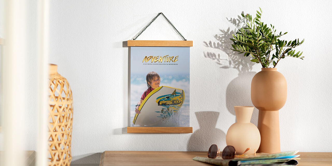 Ce poster montre un petit garçon à la plage. Il regarde en direction de l’appareil photo et tient une planche de surf. En arrière-plan, on voit la mer et ses vagues. Au-dessus, on aperçoit le ciel bleu.